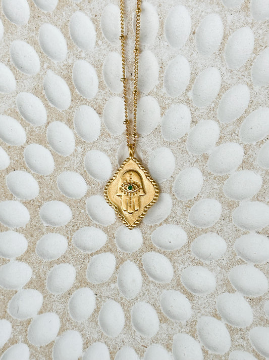 Cradled in Protection Gold and Emerald Hamsa Amulet Necklace